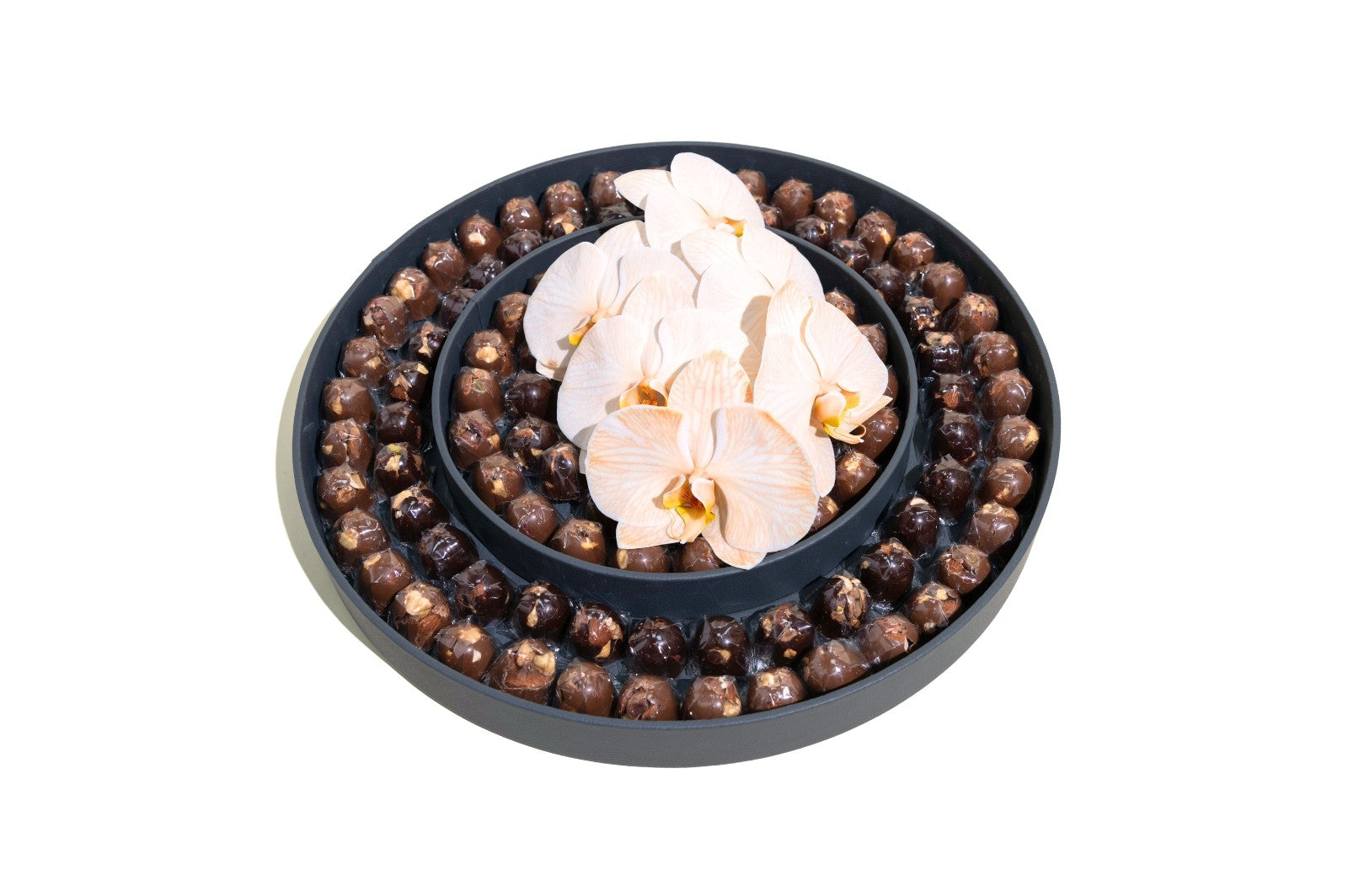 A chocolate product featuring orchid flowers, presented in a round, black container.