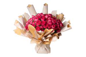 A bouquet of flowers with beige and brown paper wrapping, featuring predominantly pink and red flowers.
